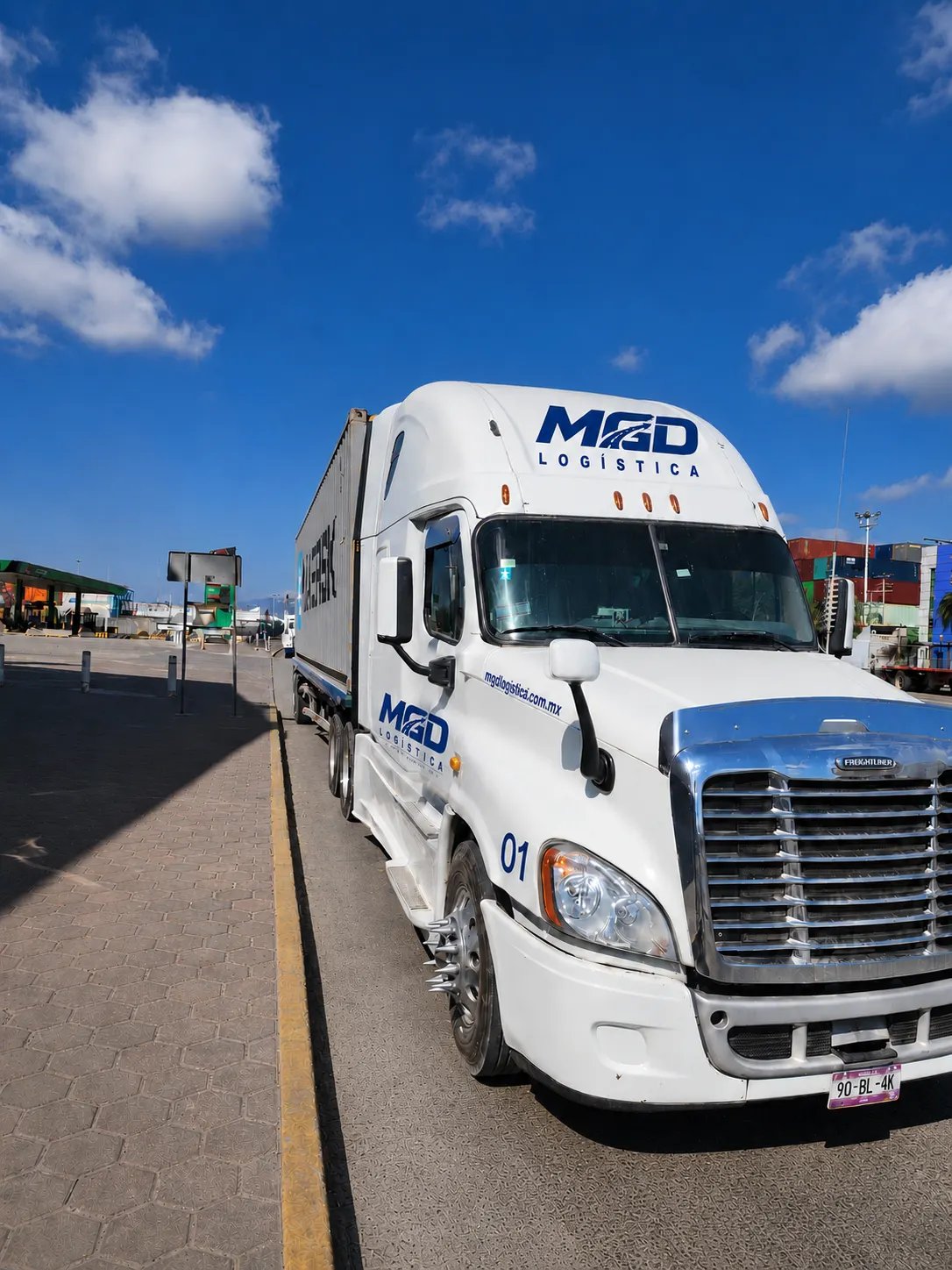 Tractocamión Freightliner Cascadia blanco de MGD, número económico 01, con un contenedor en un patio de contenedores